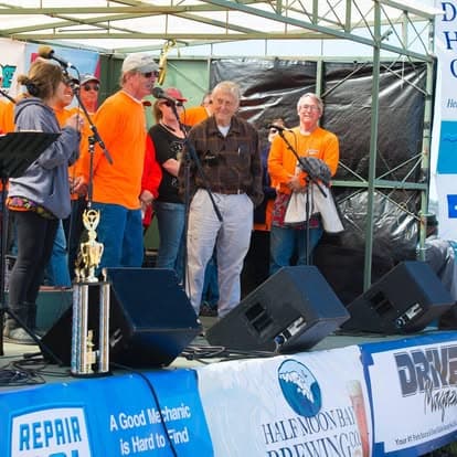 Vintage microphone and loudspeaker on stage at Pacific Coast Dream Machines event in Half Moon Bay, California, providing entertainment with live music.