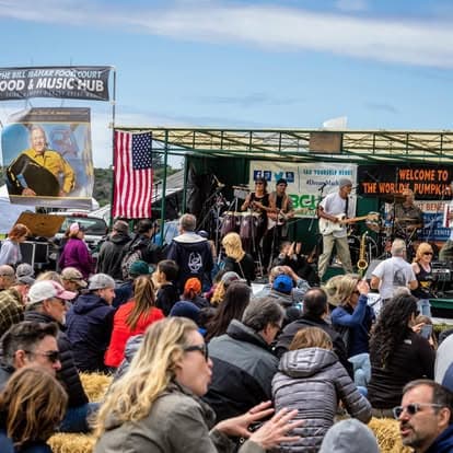 Diverse crowd enjoying vintage machines at Pacific Coast Dream Machines event in Half Moon Bay, California.