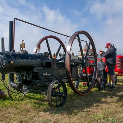 Vintage steam engine tractor with intricate spoke wheels at Pacific Coast Dream Machines event in Half Moon Bay, CA.