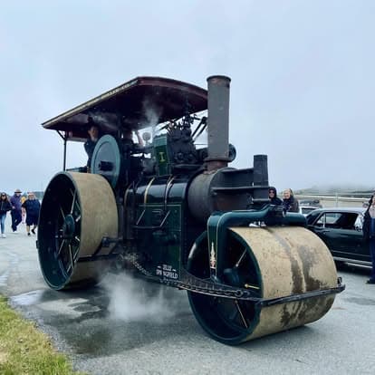 Antique steam engine tractor rolling on display at Pacific Coast Dream Machines event in Half Moon Bay, California.