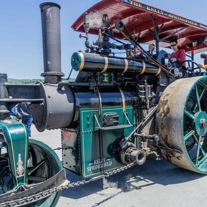 Vintage steam engine tractor with spoked wheels at Pacific Coast Dream Machines event in Half Moon Bay, California.
