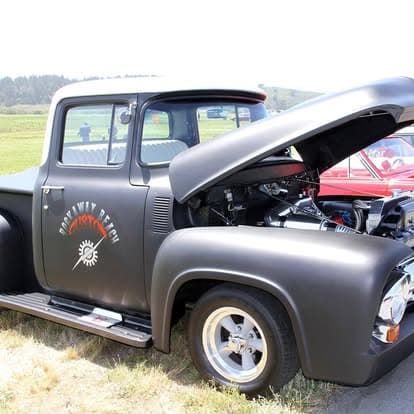 Vintage truck on display at Pacific Coast Dream Machines event in Half Moon Bay, showcasing classic automotive design with detailed grille and hood.