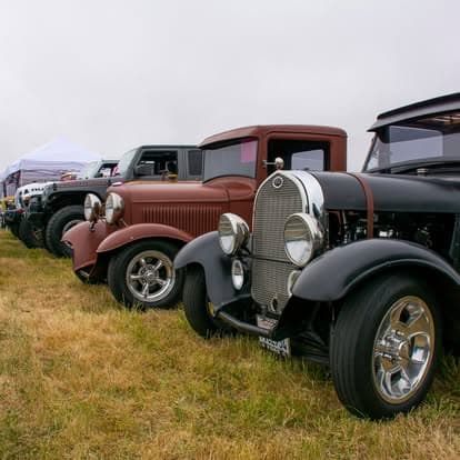 Vintage classic car with shiny chrome wheels on display at Pacific Coast Dream Machines event in Half Moon Bay, California.