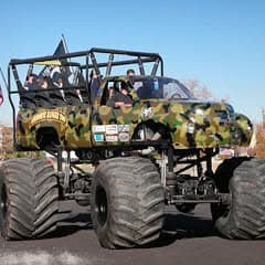 Vintage monster truck with oversized tires at Pacific Coast Dream Machines event in Half Moon Bay, California.