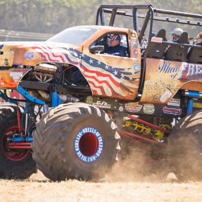 Vintage off-road monster truck with massive tires and wheels at Pacific Coast Dream Machines in Half Moon Bay, CA.
