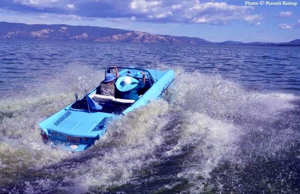 Wild Bill's 1964 Amphicar #137 cruising on a lake with mountains in the background